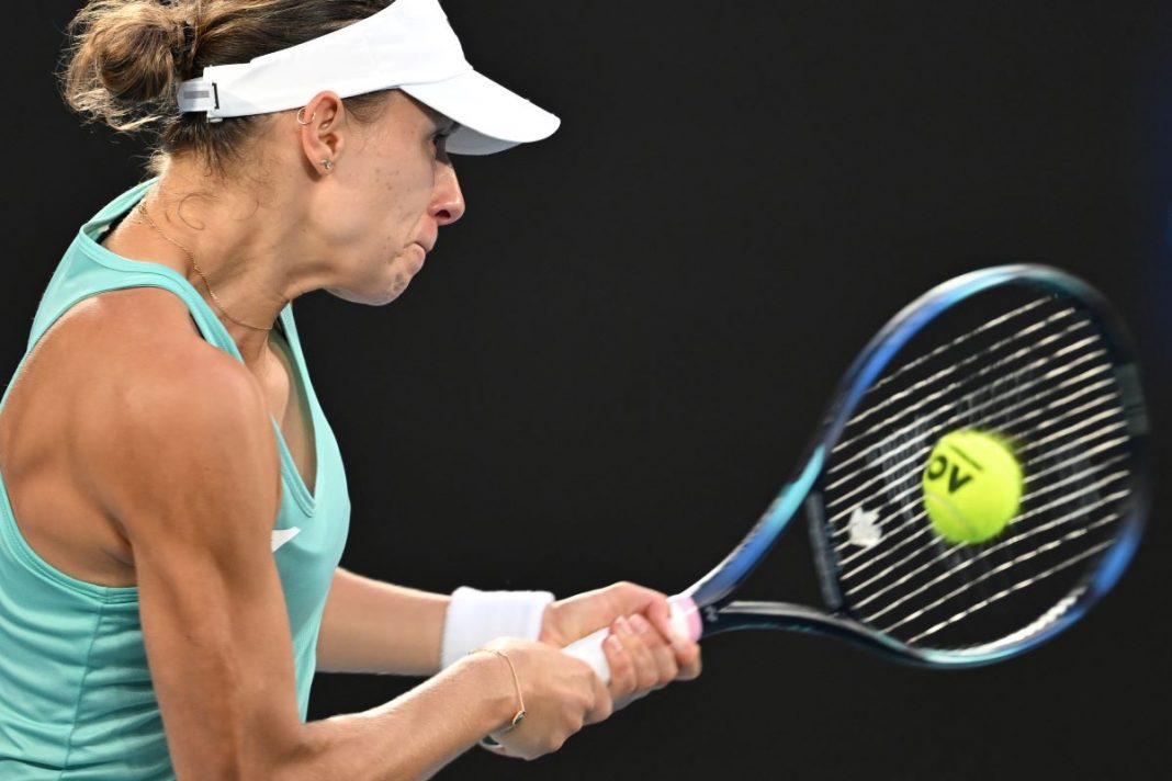 Magda Linette odbijająca piłkę na korcie.