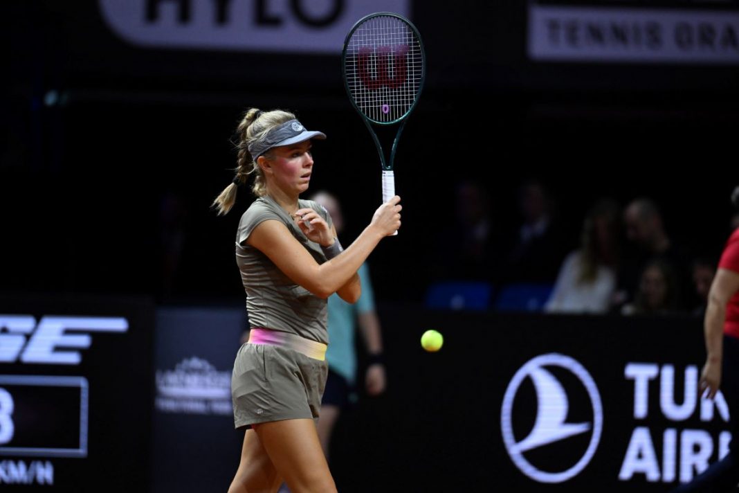 Magdalena Fręch z podniesioną rakietą na korcie.