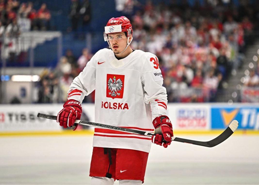 Krzysztof Maciaś na lodowisku w stroju reprezentacji Polski.