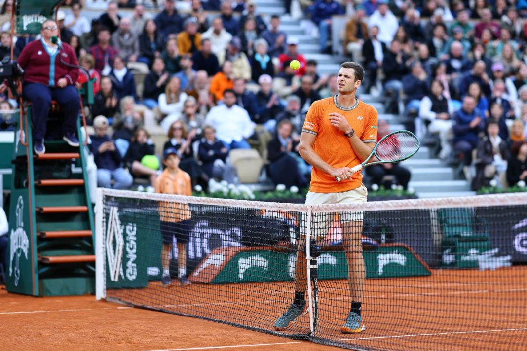 Hubert Hurkacz przy siatce na korcie.