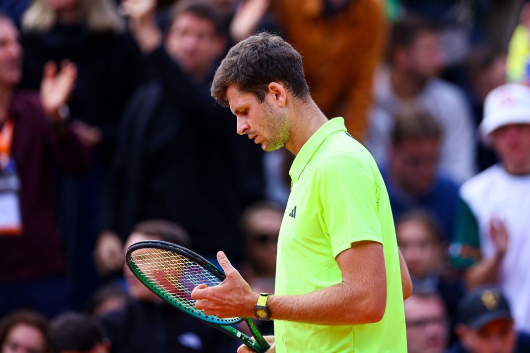 Hubert Hurkacz sprawdzający naciąg rakiety.