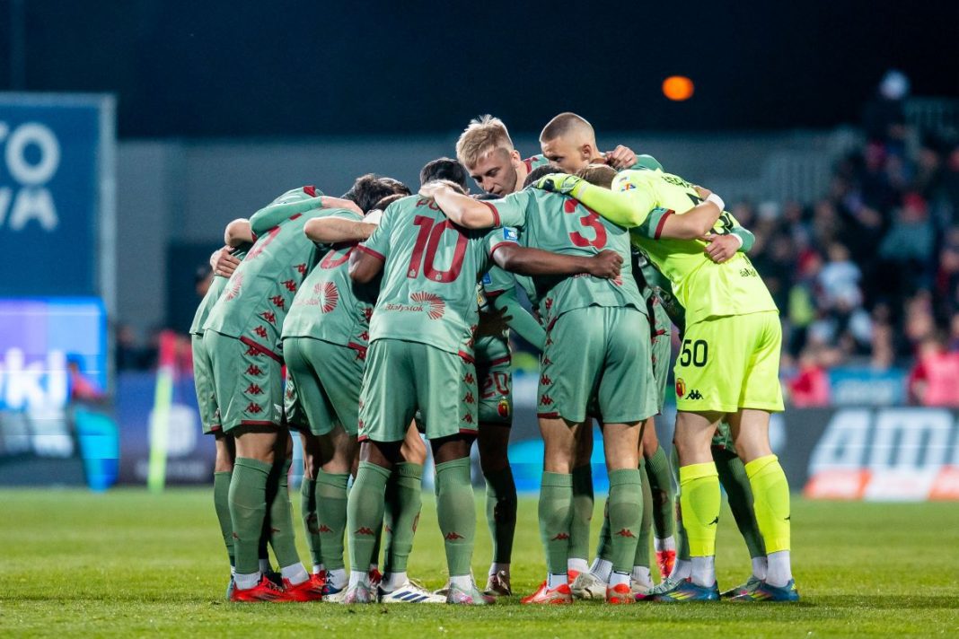 Piłkarze Jagiellonii Białystok w kółeczku przed meczem.