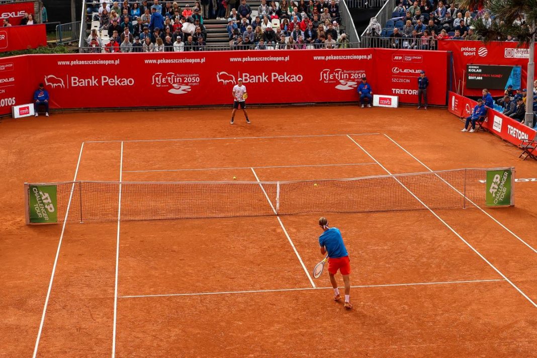 Kamil Majchrzak w trakcie gry na korcie ziemnym.