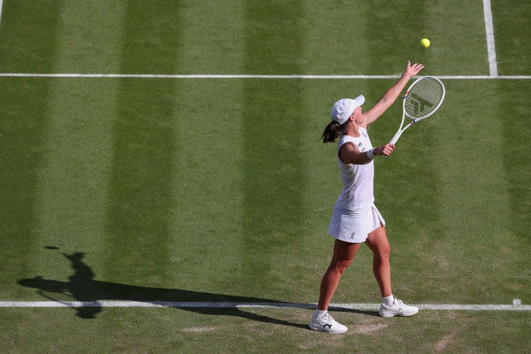 bencic-swiatek-typy-kursy-bonus Iga Świątek wykonująca serwis na korcie trawiastym.