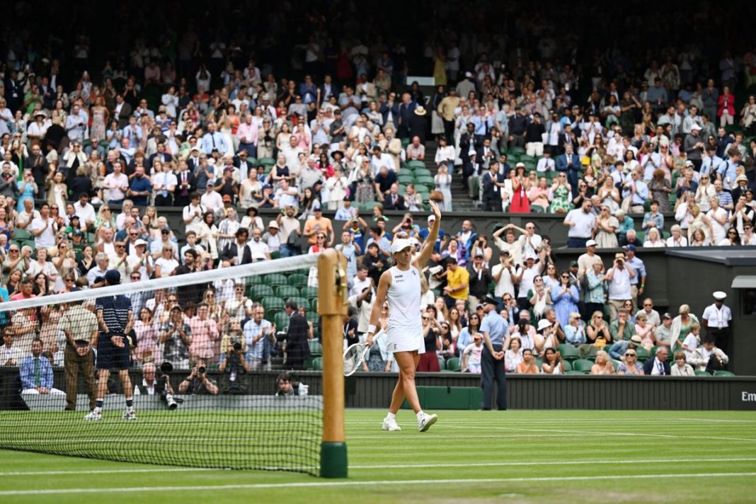 Iga Świątek pozdrawia fanów w trakcie meczu Wimbledonu.