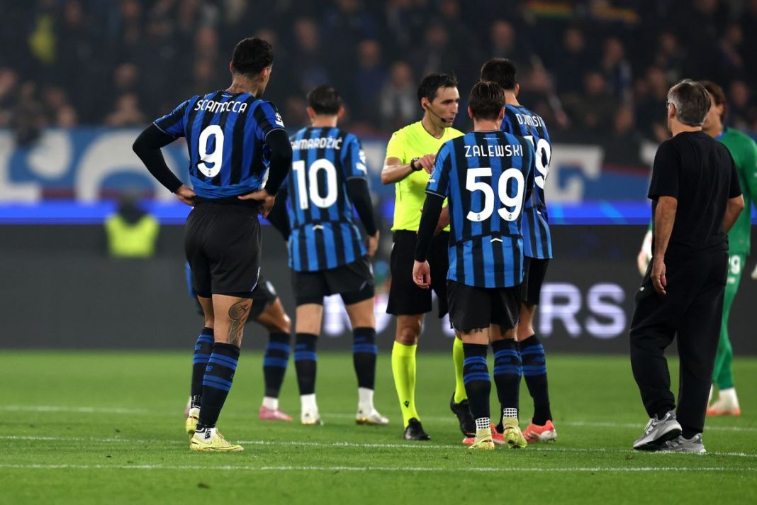 Piłkarze Atalanty rozmawiający z sędzią.