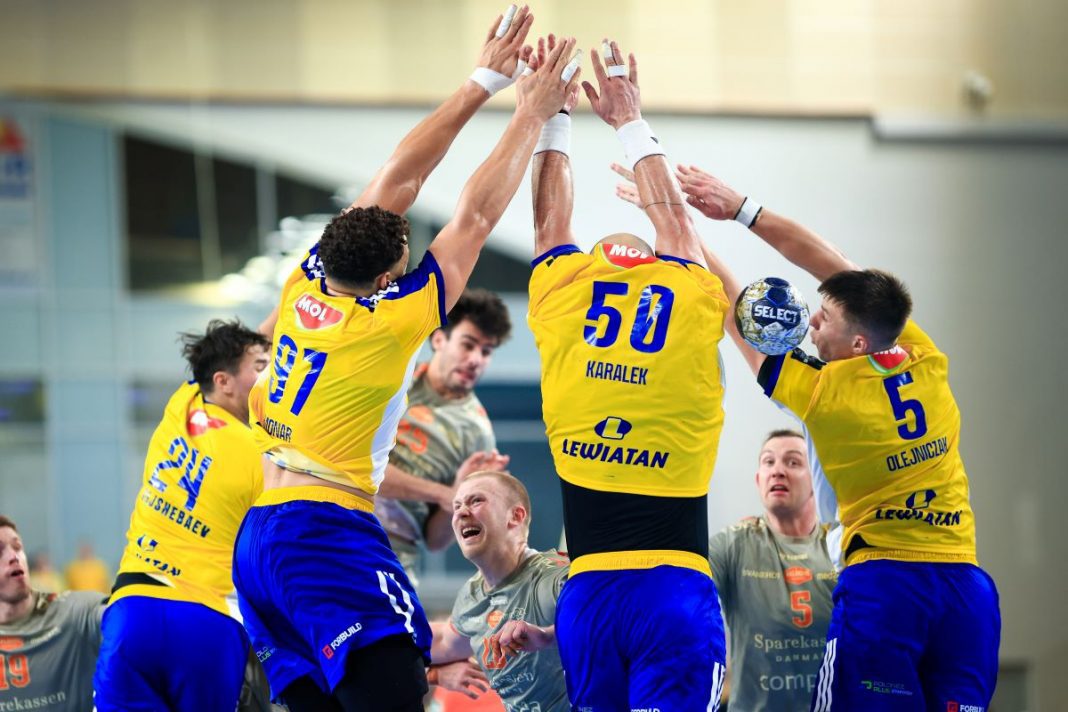 Piłkarze ręczni Industrii Kielce powstrzymują gracza Aalborga.